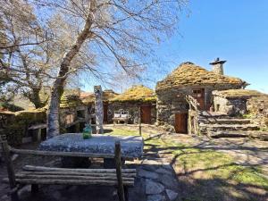 a stone house with a bench in front of it at Cardenha das Formiguinhas in Monção