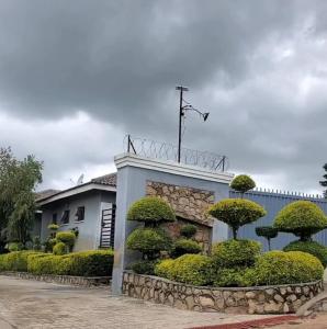 a building with bushes and trees in front of it at Alamaison in Umtali