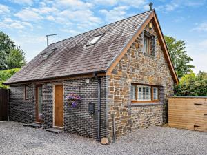 a small brick building with a brown roof at 2 Bed in Swansea oc-95129 in Penclawdd