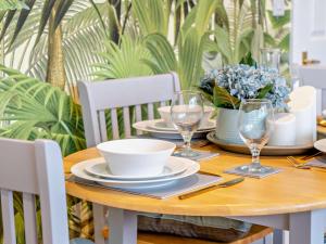 a wooden table with plates and wine glasses on it at 2 Bed in Swansea oc-95129 in Penclawdd