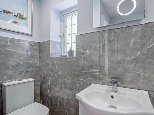 a bathroom with a sink and a toilet and a window at 2 Bed in Swansea oc-95129 in Penclawdd