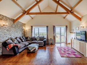 a living room with a couch and a stone wall at 4 Bed in Llanrhystud oc-92072 in Llanrhystyd