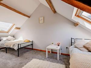 a attic bedroom with two beds and a table at 4 Bed in Llanrhystud oc-92072 in Llanrhystyd