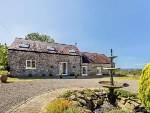 a stone house with a fountain in front of it at 4 Bed in Llanrhystud oc-92072 in Llanrhystyd