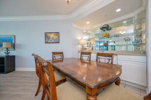 a dining room with a wooden table and chairs at Phoenix on the Bay 1409 condo in Orange Beach