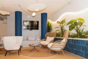 a waiting room with chairs and plants at Tuscany Hotel Alle Dune in Marina di Castagneto Carducci