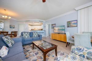 a living room with blue couches and a table at Phoenix on the Bay 1409 condo in Orange Beach +43 photos