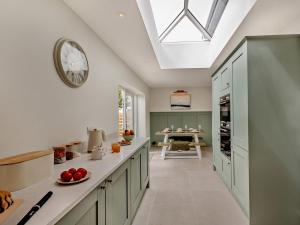a kitchen with green cabinets and a clock on the ceiling at 3 Bed in Pwllheli oc-95040 in Morfa Nefyn