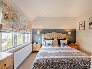 a bedroom with a large bed and a window at 3 Bed in Pwllheli oc-95040 in Morfa Nefyn