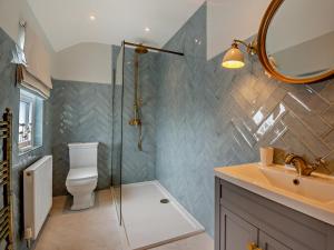 a bathroom with a toilet and a sink and a mirror at 3 Bed in Pwllheli oc-95040 in Morfa Nefyn +22 photos