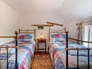 a bedroom with two beds and a table at 2 Bed in Craven Arms oc-83166 in Clun