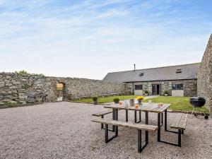 a picnic table in the courtyard of a stone building at 4 Bed in Amlwch oc-90258 in Llanfechell