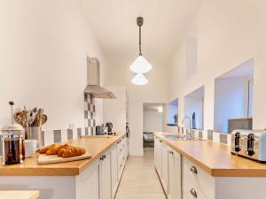 a large kitchen with white cabinets and wooden counter tops at 4 Bed in Cardigan oc-94137 in Aberporth