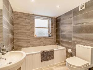 a bathroom with a toilet and a sink and a tub at 4 Bed in Cardigan oc-94137 in Aberporth +25 photos