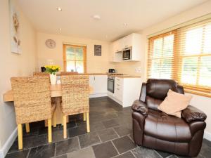 a kitchen with a table and a leather chair at 3 Bed in Narberth oc-36799 in Llawhaden +11 photos
