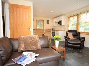 a living room with a brown leather couch and a chair at 3 Bed in Narberth oc-36799 in Llawhaden