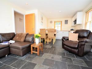 a living room with two leather couches and a table at 3 Bed in Narberth oc-36799 in Llawhaden