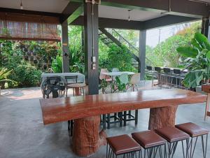 a large wooden table and some chairs and tables at ฮิมแกนแฟมิลี่เฮ้าส์ in Ban Pong (2)