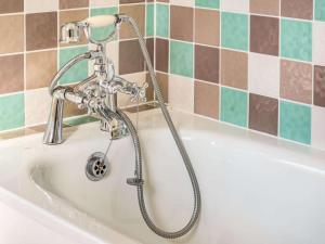 a bath tub with a shower in a bathroom at 3 Bed in Bridgend oc-57715 in Southerndown +18 photos