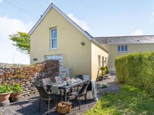 a patio with a table and chairs in front of a house at 3 Bed in Bridgend oc-57715 in Southerndown