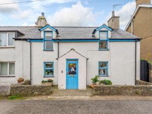 a white house with a blue door at 2 Bed in Pwllheli oc-44492 in Nefyn