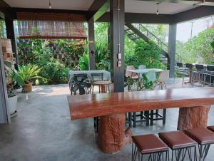 a large wooden table in a restaurant with chairs at ฮิมแกนแฟมิลี่เฮ้าส์ in Ban Pong (2)