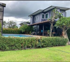 a house with a swimming pool in front of it at ฮิมแกนแฟมิลี่เฮ้าส์ in Ban Pong (2)