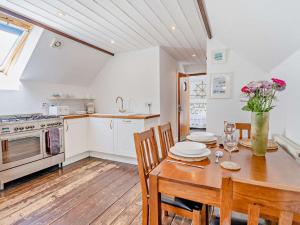 a kitchen with a wooden table with chairs and a dining room at 1 Bed in New Quay oc-45927 in New Quay +7 photos