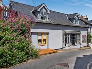 a white house with a wooden porch in a street at 1 Bed in New Quay oc-45927 in New Quay