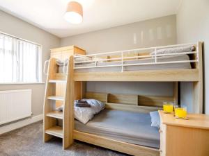 two bunk beds in a room with a desk at 3 Bed in Fairbourne oc-86841 in Fairbourne