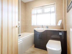 a bathroom with a toilet and a sink and a window at 3 Bed in Fairbourne oc-86841 in Fairbourne +7 photos
