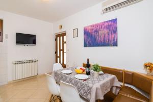 Apartment Rabac 25 في راباك: غرفة طعام مع طاولة وكراسي بيضاء
