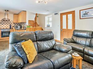 a leather couch in a living room with a kitchen at 1 Bed in Swansea oc-52906 in Llanrhidian