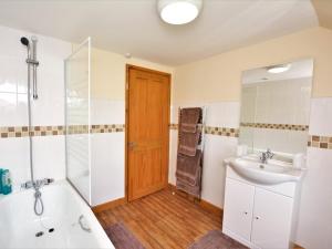 a bathroom with a tub and a sink and a shower at 1 Bed in Swansea oc-52906 in Llanrhidian