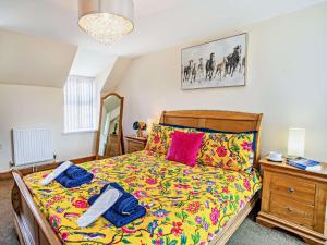 a bedroom with a bed with colorful sheets and a dresser at 1 Bed in Swansea oc-52906 in Llanrhidian