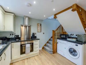 a kitchen with a washing machine and a staircase at 1 Bed in Llanrwst oc-83950 in Llanrwst