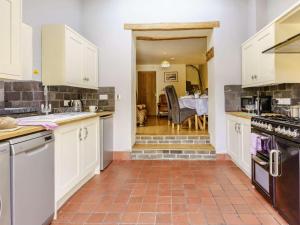 a kitchen with white cabinets and a tile floor at 2 Bed in Aberaeron oc-45333 in Aberaeron +15 photos