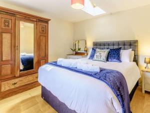 a bedroom with a large bed and a mirror at 2 Bed in Aberaeron oc-45333 in Aberaeron