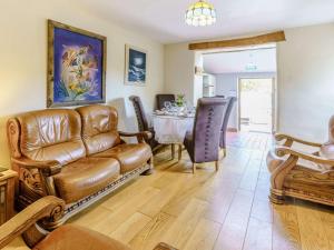 a living room with a leather couch and a table at 2 Bed in Aberaeron oc-45333 in Aberaeron