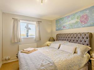 a bedroom with a bed and a window at 2 Bed in Holyhead oc-81515 in Caeʼr-geiliog