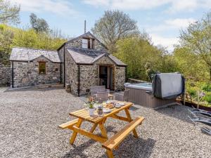a stone cottage with a picnic table and a hot tub at 2 Bed in Aberaeron oc-45333 in Aberaeron