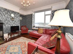a living room with a red couch and a lamp at 1 Bed in Goodwick oc-fb158 in Goodwick