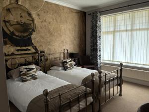 a bedroom with two beds and a clock on the wall at Westergate House in York