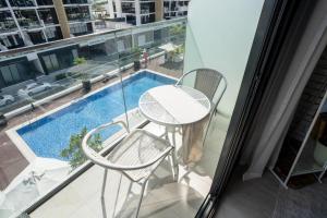 a balcony with a table and chairs and a swimming pool at Luxurious Studio Hidden Condo In Dubai in Dubai