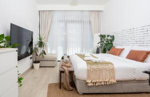 a bedroom with a large bed and a couch at Luxurious Studio Hidden Condo In Dubai in Dubai