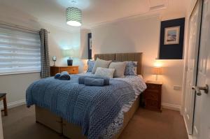 a bedroom with a bed with blue blankets and pillows at Cliffside Garden Flat in Woolacombe