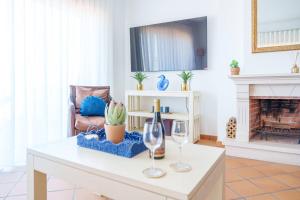 a living room with a table with two wine glasses at Sunny Ocean view, Praia del Rey A7 in Óbidos