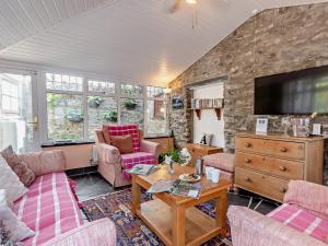 a living room with pink furniture and a stone wall at 2 Bed in Colwyn Bay oc-50933 in Eglwys-Fâch