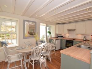 a kitchen with a table and chairs in a kitchen at 3 Bed in Conwy oc-tygos in Llangelynin