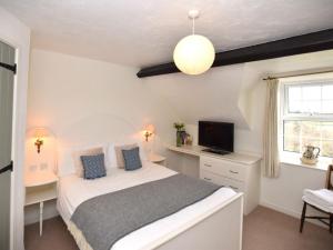 a bedroom with a bed with a desk and a television at 3 Bed in Conwy oc-tygos in Llangelynin